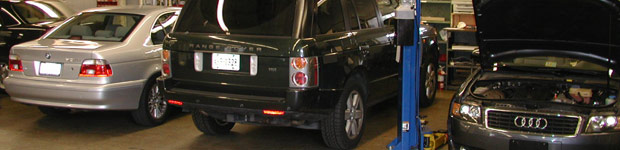 A black suv parked in a garage with its lights on.
