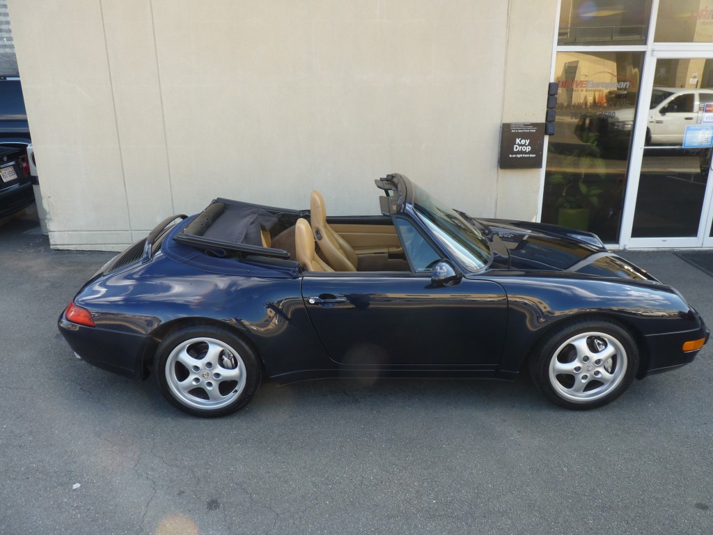 A blue sports car parked in front of a building.