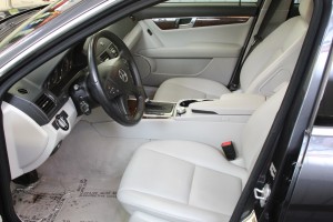 A car with white leather seats and black steering wheel.