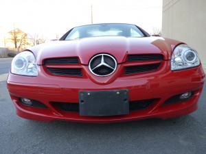 A red mercedes benz is shown with its front end.
