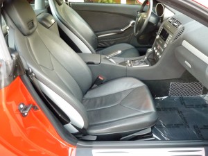 A car with black leather seats and a red door.