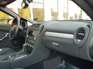 A car dashboard with the steering wheel and center console.