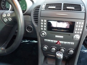A car dashboard with the steering wheel and radio.