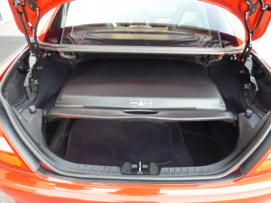 A car trunk with the door open and its lid opened.