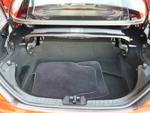 A car trunk with the floor mats folded down.