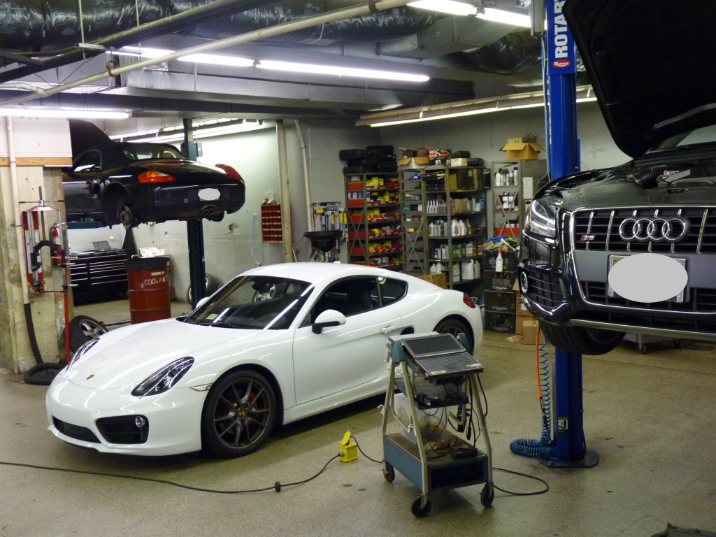 A white car in the middle of a garage.