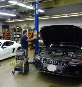 A man working on an audi car in a garage.