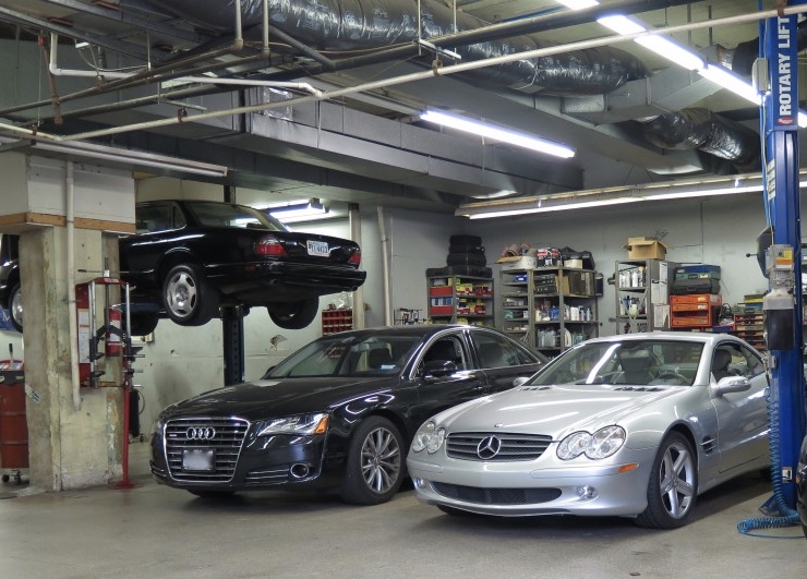 A garage with three cars parked on the floor.