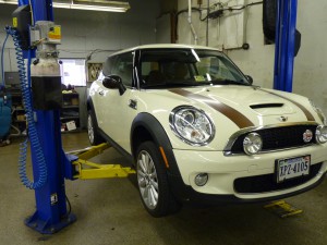 A white mini cooper parked in a garage.
